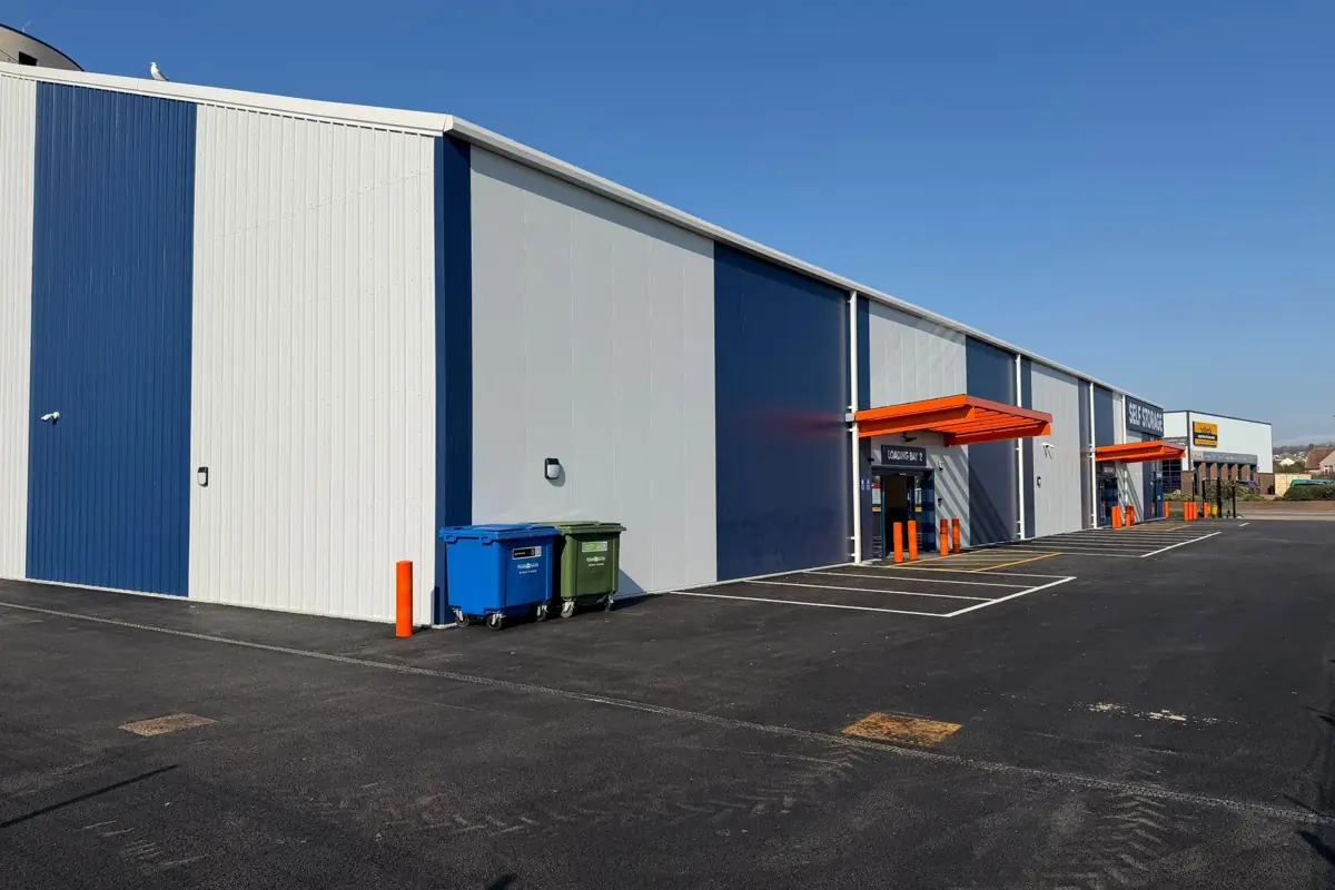 The flank elevation and loading bays clad in navy and white panels