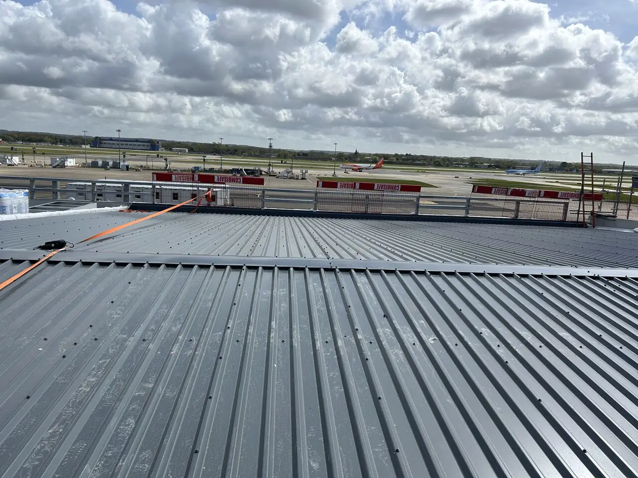 New profiled metal roof sheeting with the Gatwick airfield beyond