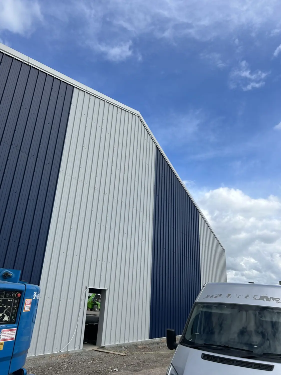 A tall warehouse elevation in navy and silver profiled wall cladding