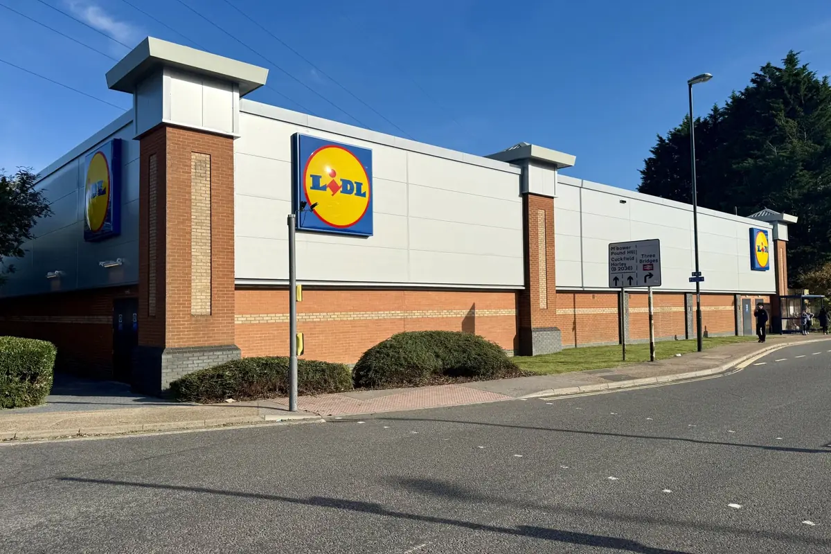 A Lidl store elevation finished in white composite panels above a brick plinth