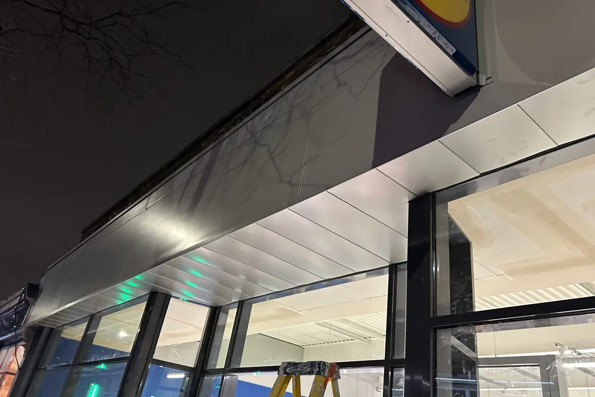 A newly installed metal shopfront soffit and fascia lit up at night