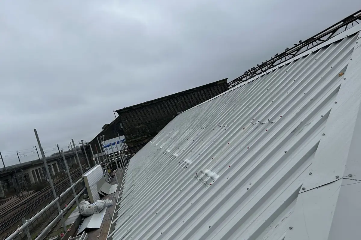 The completed trackside roof, sheeted and flashed, beside the railway