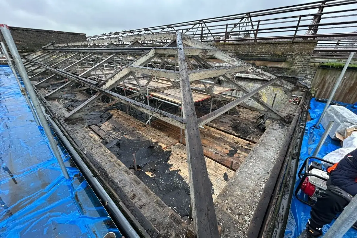 A roof stripped back to bare timber and steel trusses with the decking removed