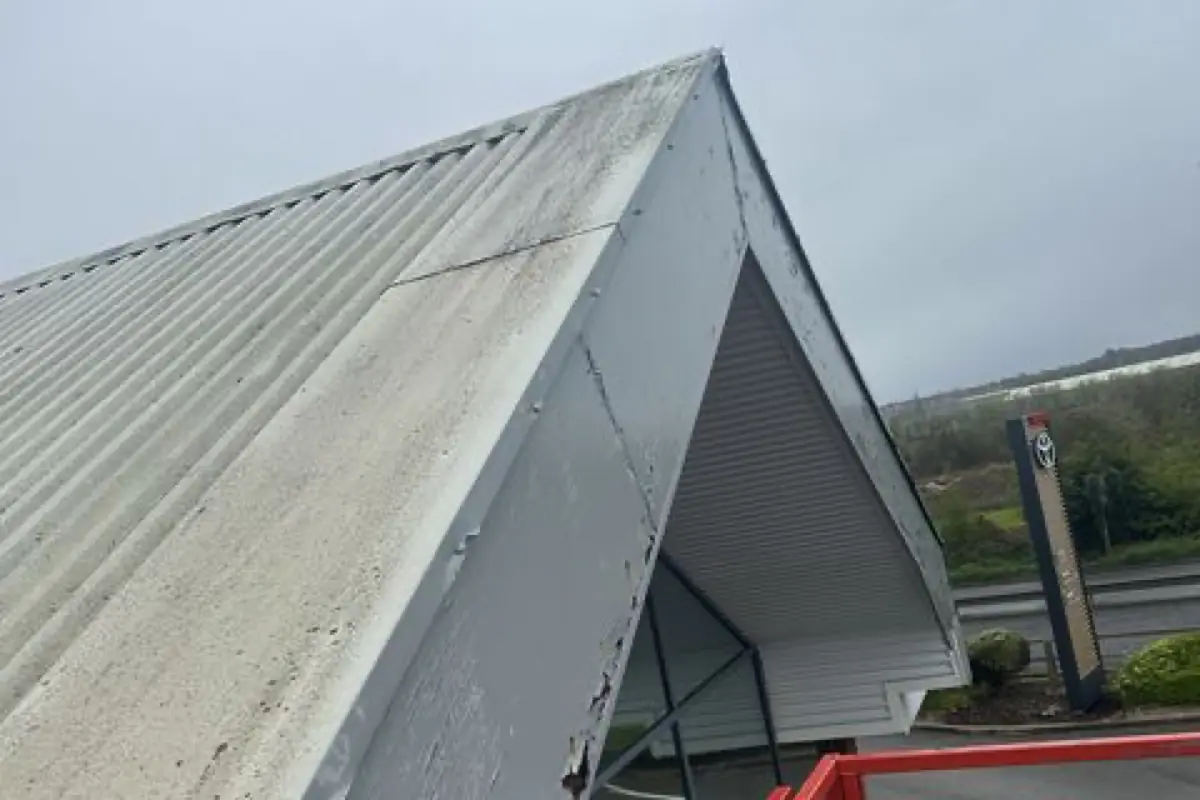 The dealership roof edge and new flashings seen from a powered platform